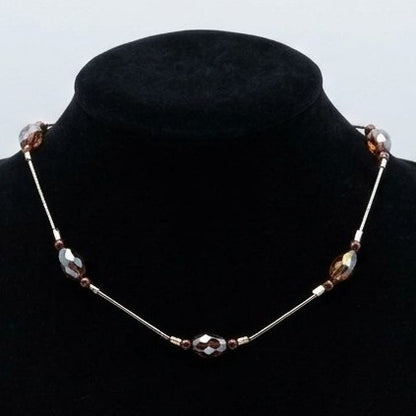Floating bead choker necklace with smooth and faceted beads, displayed on a black jewellery stand.